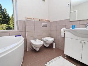 a bathroom with a toilet and a tub and a sink at Apartment with terrace and garden in Vela Luka +20 photos