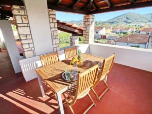 a wooden table and chairs on a balcony with a view at Apartment with terrace and garden in Vela Luka