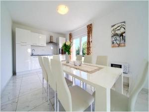 クルクにあるVilla Isabella - Four Bedroom Villa with Swimming Poolの白いテーブルと椅子のある白いダイニングルーム