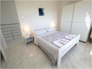 クルクにあるVilla Isabella - Four Bedroom Villa with Swimming Poolのタオルが敷かれた白いベッドのある寝室