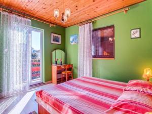 a bedroom with green walls and a bed and a desk at Apartment Blamax with Terrace and Sea View in Mali Lošinj
