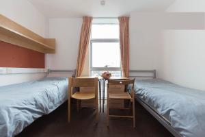 a bedroom with two beds and a table and chairs at Davies Court (Canary Wharf) in London