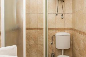 a bathroom with a shower with a toilet in it at Apartments Maria Kolo ep - Two Bedroom Apartment with Terrace and Garden View in Koločep