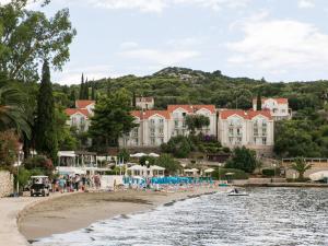a hotel on the shore of a beach with chairs at Apartments Maria Kolo ep - Two Bedroom Apartment with Terrace and Garden View in Koločep
