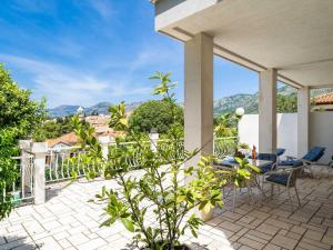 d'une terrasse avec une table, des chaises et des montagnes. dans l'établissement Apartments & Rooms Mara & Petrunjela - Two Bedroom Apartment with Terrace and Sea View, à Cavtat