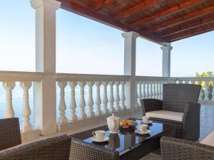 a patio with a table and chairs on a balcony at House Green Side Sunset- Four Bedroom House with Pool and Sea View in Prigradica