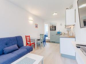a living room with a blue couch and a kitchen at Apartment Karlo - Two Bedroom Apartment with Balcony Matani in Kaštela
