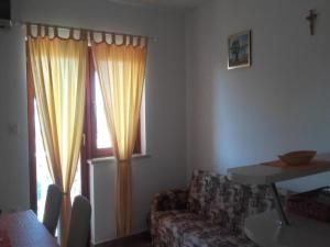 ein Wohnzimmer mit einer Couch und einem Tisch und einem Fenster in der Unterkunft Apartments Smilje i Maslina - One Bedroom Apartment with Terrace 2 in Gornji Karin