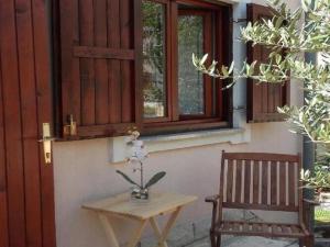 einem Holztisch und einer Bank neben einem Fenster in der Unterkunft Apartments Smilje i Maslina - One Bedroom Apartment with Terrace 2 in Gornji Karin