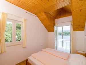 ein Schlafzimmer mit einem Bett und einem Fenster in der Unterkunft Holiday Home Ma us-One Bedroom Apartment with Balcony in Koločep