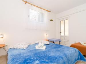 a bedroom with a blue bed with two towels on it at Apartments Villa Dinga - Borak - Standard One Bedroom Apartment with Balcony and Sea View No 3 in Potomje