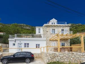 ein schwarzes Auto, das vor einem Haus geparkt ist in der Unterkunft Villa Dundo Pero - Four Bedroom Villa with Swimming Pool and Sea View in Babino Polje