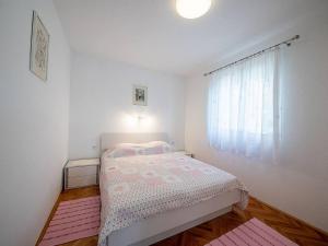 a small bedroom with a bed and a window at Apartments Magdalena - Standard Apartment with Terrace and Sea View A2 in Bol