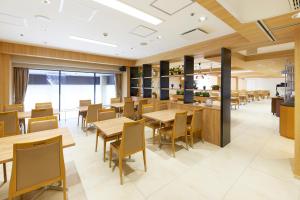 a restaurant with wooden tables and chairs and a cafeteria at Hotel Consort Shin-Osaka in Osaka