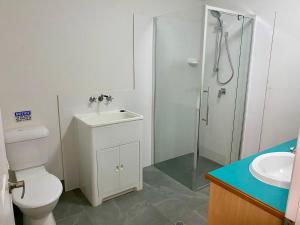 a bathroom with a shower and a toilet and a sink at Villa 25 Coral Cove Resort in Bargara +9 photos