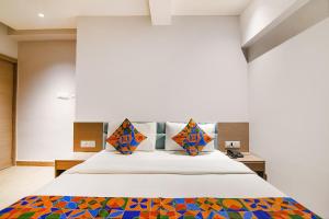 a bedroom with a large bed with colorful pillows at FabHotel Sivalika Inn - Howrah in Kolkata