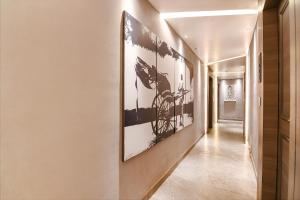 a hallway with black and white paintings on the walls at FabHotel Sivalika Inn - Howrah in Kolkata