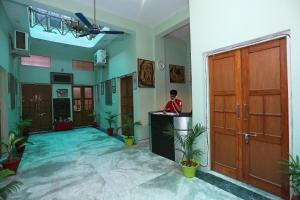 un hombre de pie en un escritorio en una habitación con vestíbulo en Super Collection-O Sara Grand Near Ram Manohar Lohia hospital, en Lucknow 45 fotos más