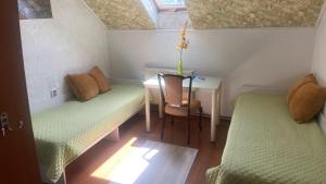 a small room with a table and two beds and a desk at FKoka in Berehove