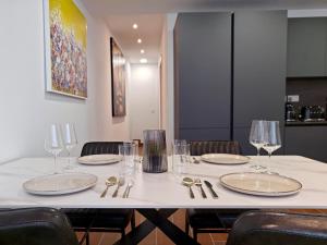 a table with chairs and plates and wine glasses at Seascape 19 in Mellieħa