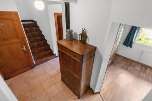 a room with a wooden dresser and a staircase at Joli studio style chalet in Euseigne