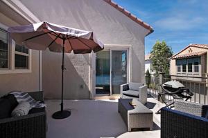 a patio with an umbrella and chairs on a balcony at Fun In The Sun 2 Bed 2 Bath Home in Oceanside