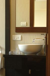 a bathroom counter with a sink and a mirror at Hotel Amigo in Mumbai