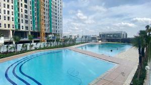 a large swimming pool on top of a building at Homey and Cozy Designed 2BR at Tokyo Riverside PIK 2 Apartment By Travelio in Rawalembang
