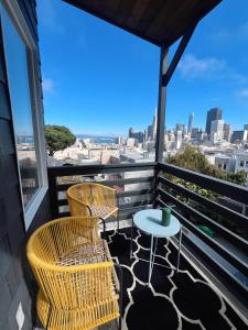 a balcony with two chairs and a table with a view at Charming 2BR Cottage with Bay and City Views-Gated Luxury Private Place in San Francisco