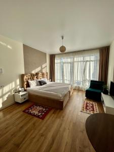 a bedroom with a bed and a large window at White apartment in Minda +85 photos