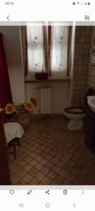 a bathroom with a toilet and a sink and window at A Santy's House 1piano-no lift-raggiungibile a piedi aeroporto-fermata bus fiera di roma a 3 minuti-NO ANIMALI bed FOR A FEE A PAGAMENTO in Fiumicino +28 photos