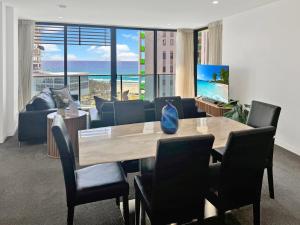a living room with a table and chairs and a couch at Oracle 11th floor Tower 1 - GC Getaways in Gold Coast