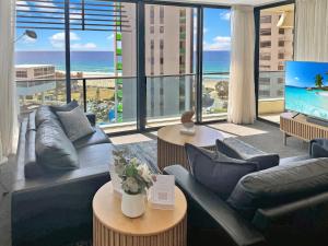 a living room with a couch and a television with a view of the ocean at Oracle 11th floor Tower 1 - GC Getaways in Gold Coast +28 photos