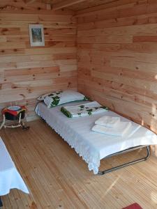 a bedroom with a bed in a wooden cabin at CABANE Nadejda SPERANTA in Găgeni