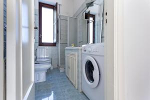 a bathroom with a washing machine and a toilet at Villa Stella in Marsala