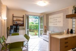 a kitchen and living room with a table and chairs at Elegante & Centrale Relax a 2 min dalle QC Terme in San Pellegrino Terme