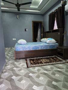 une chambre avec un lit et un tapis au sol dans l'établissement Edna Apartments, à Aba 8 autres photos