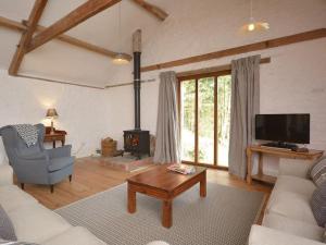 a living room with a couch and a tv at The Granary, Barwick in Yeovil