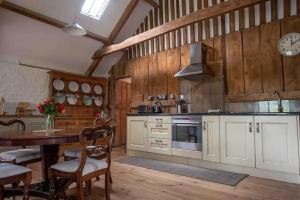 a kitchen with a table and a dining room at The Granary, Barwick in Yeovil