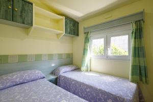 Dos camas en una habitación con ventana. en Bungalow A, en Pontevedra 20 fotos más