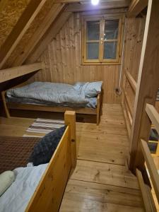 a room with two beds in a wooden cabin at PETRA kuća za odmor in Vrbica
