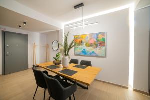 a dining room with a wooden table and chairs at VersusArtSuites in Serres