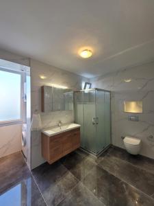 a bathroom with a sink and a shower and a toilet at Limon Çiçeği Alaçatı - Serkan's Villa in Ilıcaköy