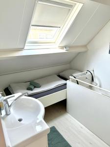 a bathroom with a sink and a toilet and a window at Zomerhuis Rita in Egmond aan Zee +28 photos
