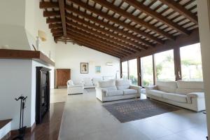 a living room with white couches and a fireplace at Villa delle Muse in Marsala