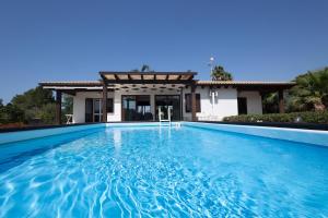 a swimming pool in front of a house at Villa delle Muse in Marsala