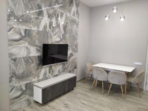 a dining room with a table and a tv on a wall at Very beauty new apartment for good guests in Arabkir