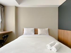 a bedroom with a bed with two towels on it at Good Choice and Cozy Studio Gateway Park LRT City Jatibening Apartment By Travelio in Bekasi +10 photos