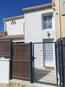 une clôture avec un portail en face d'une maison dans l'établissement Maison Duplex, à Pierrelatte