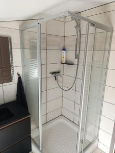 une douche avec une porte vitrée dans une salle de bain dans l'établissement Maison Duplex, à Pierrelatte 9 autres photos
